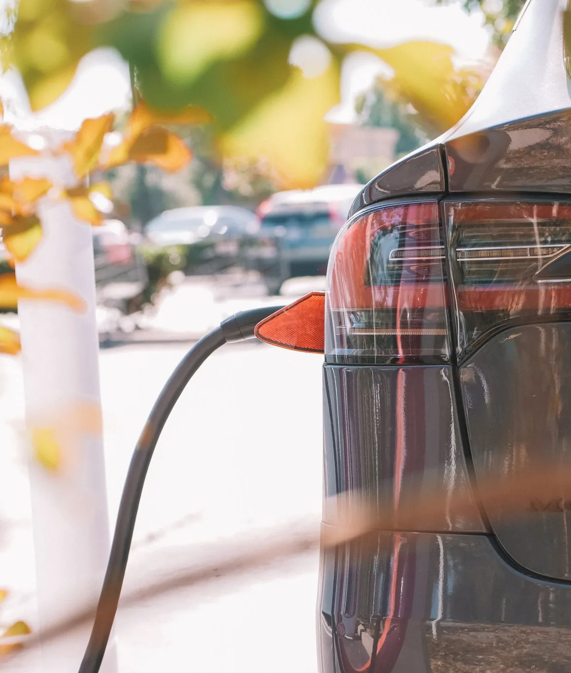 Electric vehicle plugged into a charging station outdoors