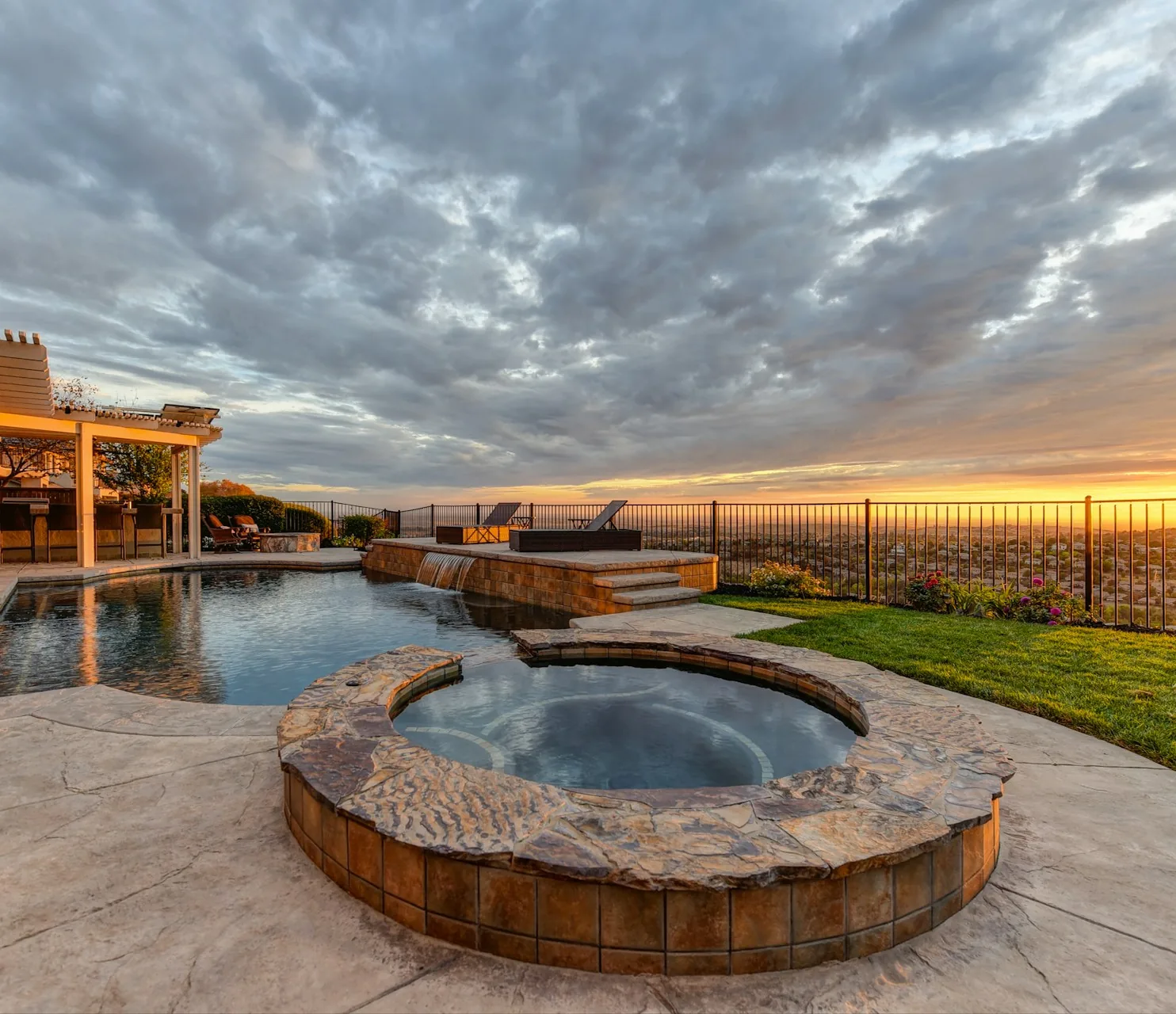 Outdoor spa and swimming pool beside a patio